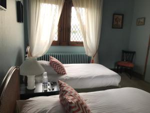 ReillyDOMAINE ST GERMER的客房设有两张床和一张带台灯的桌子。