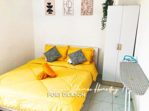 波德申Laguna Damai Homestay Teluk Kemang PD 3BR- Pool View的一间卧室配有一张带黄色床单和枕头的床。