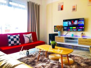 波德申Laguna Damai Homestay PortDickson - "PoolView & BeachNearby"的客厅配有红色沙发和电视