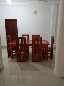希克杜沃Minsara Villa的一间带木桌和椅子的用餐室