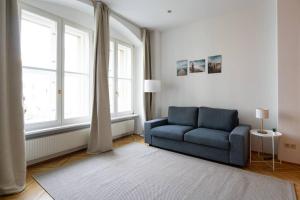 维也纳Vienna Central Panorama的客厅设有蓝色的沙发和窗户。