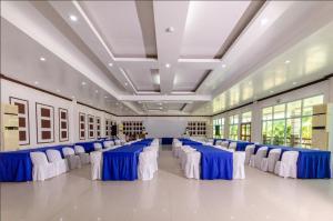 Magsaysay Hillside Resort powered by Cocotel的大型宴会厅配有蓝色和白色的桌椅