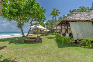 高兰Layana Resort & Spa - Adult Only - SHA Extra Plus的海滩上带椅子和遮阳伞的度假村