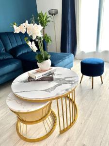 勒布朗-梅尼尔Perle rare « Le Cosy de CDG »的客厅配有咖啡桌和蓝色沙发