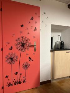 戈尔多拉Sirogn House的一个带红色门的厨房,里面装有蝴蝶和蒲公英
