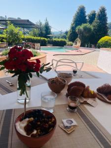 卡麦奥雷Villa Belvedere Versilia - Villa con tre camere, cucina, sala, giardino con piscina e vista - 7 posti letto的桌子上放着食物和花瓶