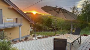 WeiÃŸbachFerienwohnung im Erzgebirge的庭院配有遮阳伞和桌椅。