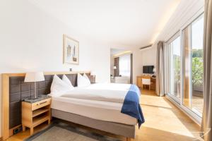 达沃斯Swiss Quality Turmhotel Victoria的一间卧室设有一张大床和大窗户