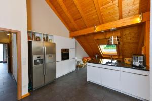 WeiÃŸbachFerienwohnung im Erzgebirge的厨房配有不锈钢用具和木制天花板