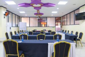 VoiTwo Oceans Hotel Voi的一间会议室,配有蓝色的桌子和黄色的椅子
