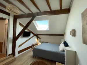 比亚里茨LA CHOUETTE DU LAC MARION的卧室配有一张床铺,位于带木梁的房间