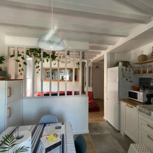 比亚里茨LA CHOUETTE DU LAC MARION的厨房配有白色橱柜和白色冰箱。