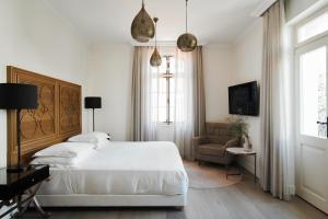 特拉维夫The Drisco Hotel Tel Aviv - Relais & Châteaux的白色卧室配有床和椅子