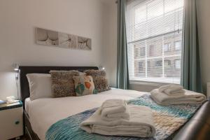 伦敦Experience Vibrant Covent Garden - The Wanderlust by SmartStays的一间卧室配有带毛巾的床