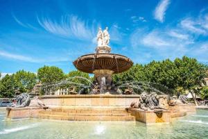普罗旺斯艾克斯Le Cardinale - Un Voyage en Provence的阳光明媚的日子,公园里的喷泉