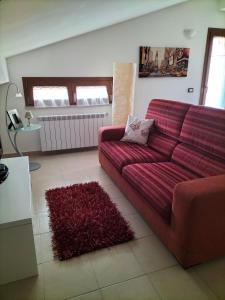 拉奎拉Come a casa的客厅配有红色沙发和地毯。