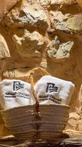 Al ‘AqarHanging Terraces المدرجات المعلقة的石墙前带毛巾的篮子