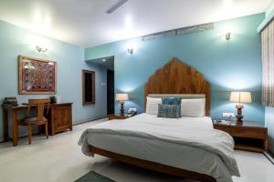 焦特布尔杏仁树住宿加早餐旅馆的一间卧室设有一张大床和蓝色的墙壁