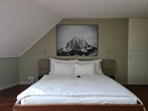 卢塞恩卢塞恩湖景公寓的卧室配有一张白色大床,墙上挂着一幅画