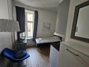 奥斯陆Keybutler Royal Park Studios的小房间设有一张床和一张蓝色椅子
