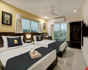 艾哈迈达巴德Leo Hotel的一间卧室设有两张床和窗户。