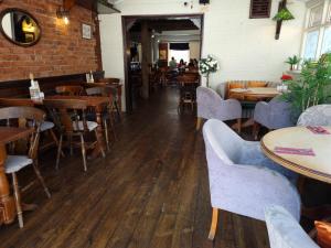 南安普敦The Bugle Inn的餐厅设有木桌和椅子,拥有砖墙
