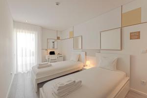 波尔图Uporto House Residence的白色的客房配有两张床和一张书桌