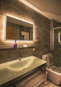 亚的斯亚贝巴The Row Residential Hotel的一间带水槽、镜子和卫生间的浴室