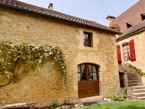 Saint-CybranetL'appartement du Pont de Cause的一座古老的石头房子,设有木门和楼梯