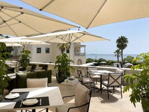 卡斯卡伊斯格兰瑞沃伊塔里Spa酒店的一间设有白色桌椅和遮阳伞的餐厅