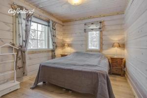 伊瓦洛Hallahaukka的木制客房内的一间卧室,配有一张床