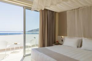 林都斯Lindos Village Resort & Spa - Adults Only的一间卧室配有一张床,享有海景