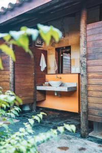 卡姆布库Pousada Meeting Point & KiteSchool的橙色浴室设有水槽和镜子