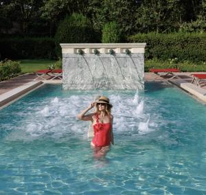 菲乌米奇诺QC泰尔梅罗玛SPA度假酒店的站在游泳池的水中的女人