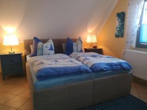 格洛韦Ferienhaus-Seehund的一间卧室配有一张带蓝色床单和枕头的床。