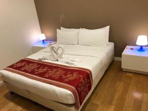 吉隆坡KLCC Ritz Residence Platinum的酒店客房的床铺上带一条带