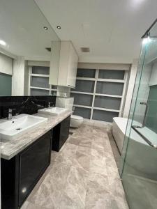 吉隆坡KLCC Ritz Residence Platinum的浴室配有2个盥洗盆、卫生间和淋浴。