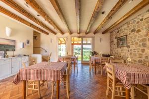 马罗斯蒂卡L'Oro Rosso的一间带桌椅和石墙的用餐室