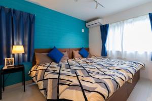 富士吉田市MIYABI Highland Terrace Villa B的一间卧室配有一张带蓝色墙壁的大床