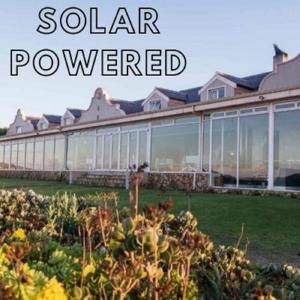 萨尔达尼亚Blue Bay Lodge的一座花园,在一座建筑前面,用太阳能供电
