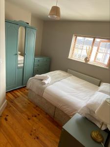 戈尔韦Cosy 4 Bedroom Galway House with Rear Garden Patio的一间卧室配有一张床和一个蓝色的橱柜