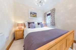 科尼斯顿Springbank Cottage, luxury Lake District cottage in Coniston的一间卧室设有一张大床和一个窗户。