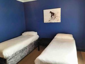 纽基Central Newquay Terrace House的一间设有两张床的房间和一个骑着滑雪板的人