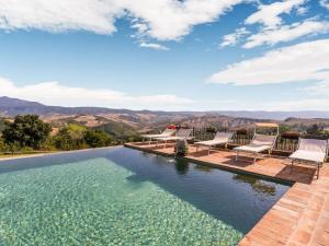 塞尔苏里格Comfortable apartment with stunning views near hot springs的一座带椅子和山脉背景的无边泳池