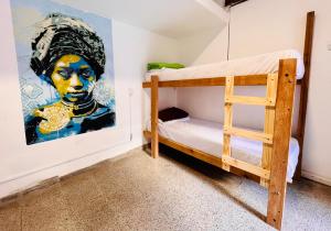 科尔多瓦Lacandona Hostel的卧室配有双层床,墙上挂有绘画作品
