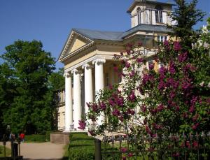 斯伽尔达克里姆达斯庄园旅舍的一座白色的大建筑,有柱子和粉红色的花朵