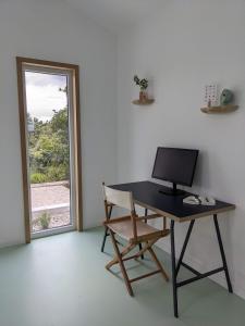 卡尔达斯达·赖尼亚Modern and spacious Cork House with private valley view的一张桌子,窗户前配有一台电脑和一把椅子