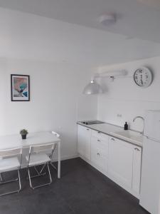 索塞莱潘La Locomotive的白色的厨房,墙上有桌子和时钟