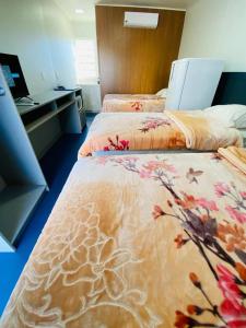 沙佩科LOFT PRÓXIMO AO FORUM的酒店客房,配有两张带鲜花的床