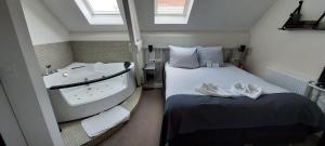 拉姆斯东克斯费尔赫尔酒店的一间卧室配有浴缸和带毛巾的床。
